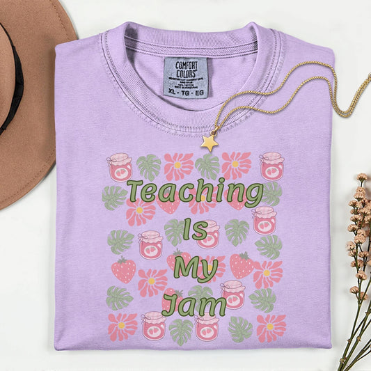 Women’s orchid  t-shirt for teachers with the phrase teaching is my jam, strawberry and green leaves perfect teacher gift.