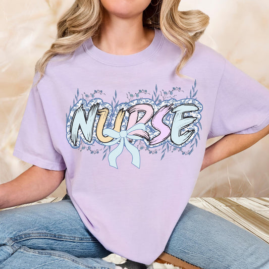Women’s orchid nurse t-shirt with the word nurse in a pastel blue floral print, gift for nurses