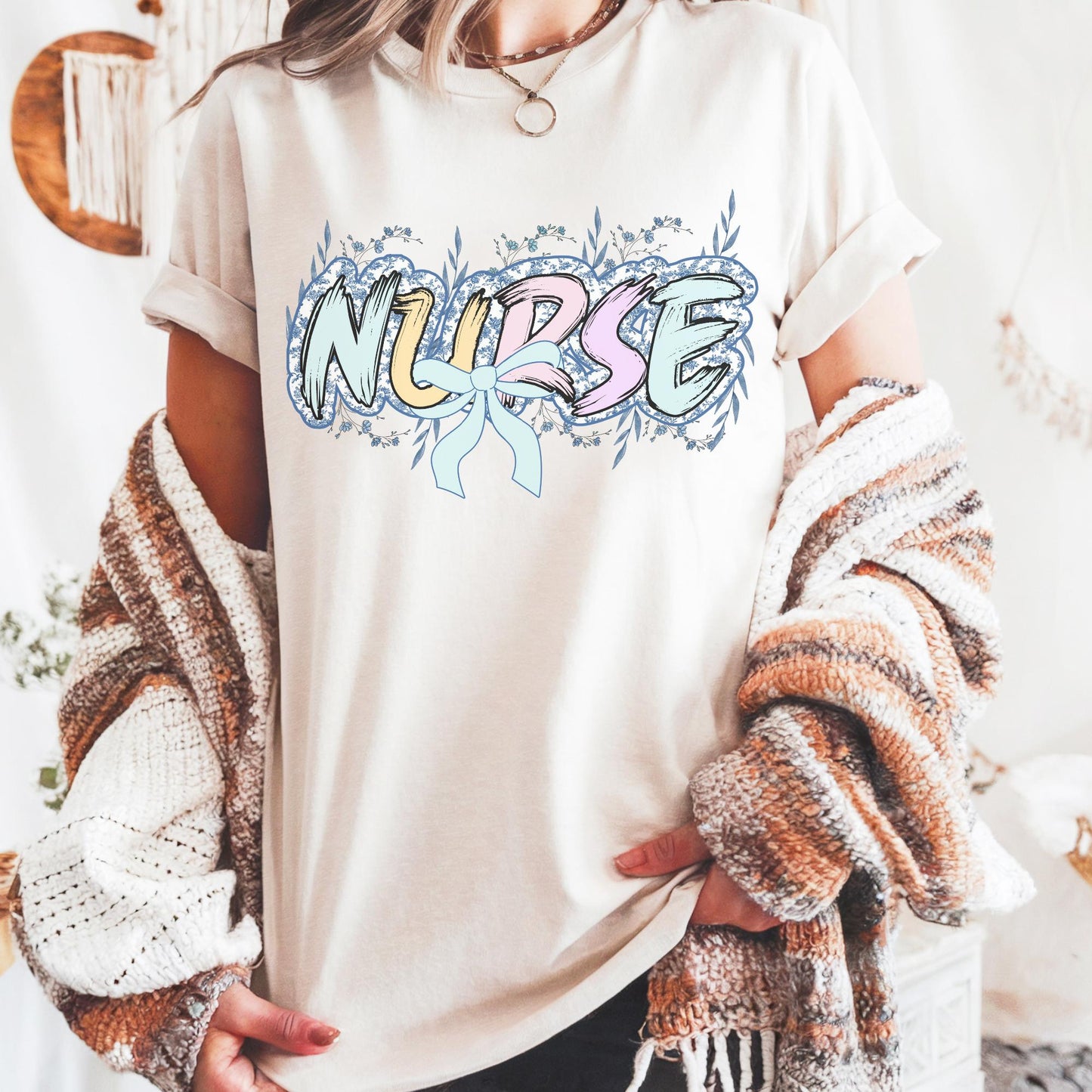 Women’s ivory nurse t-shirt with the word nurse in a pastel blue floral print, gift for nurses