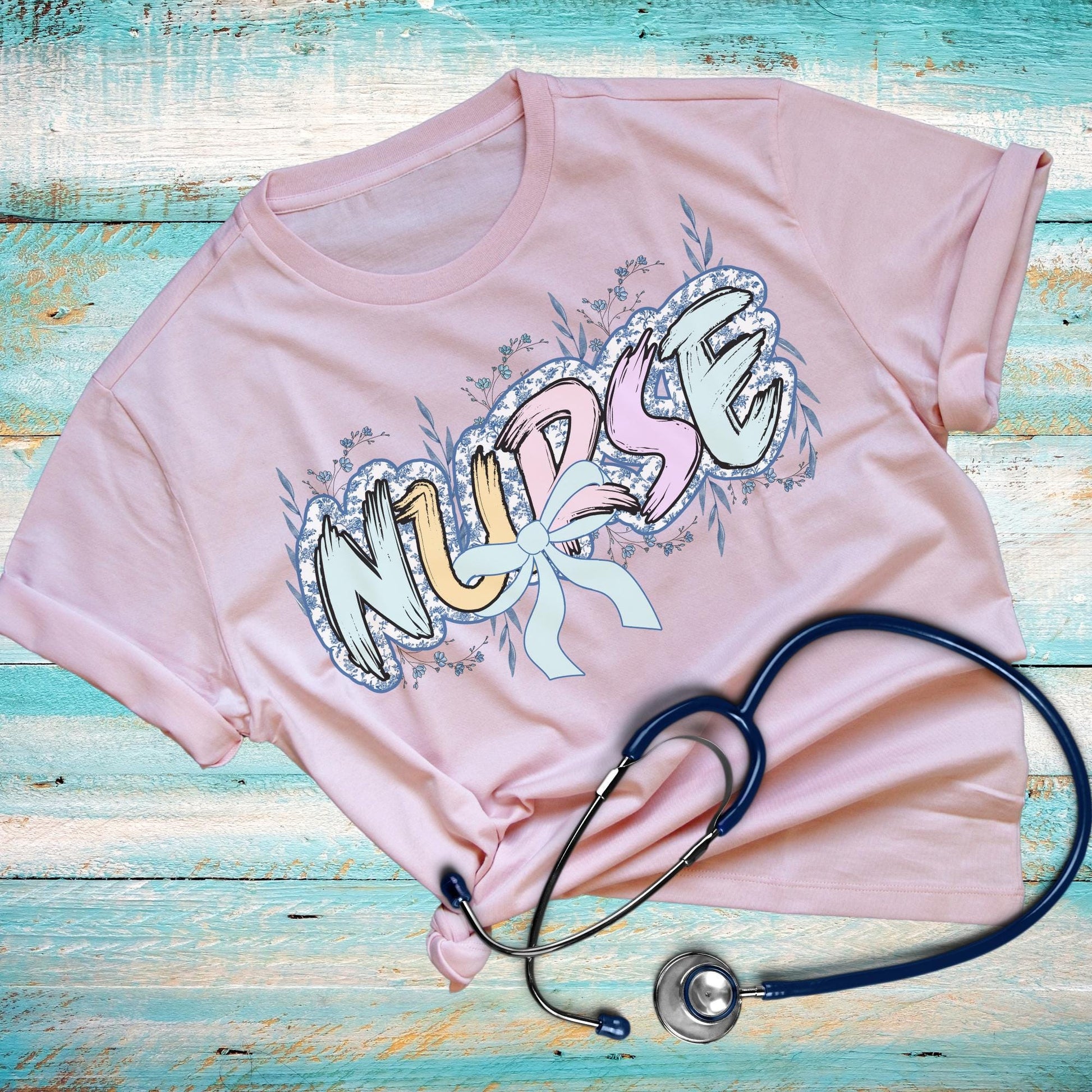 Women’s Pink nurse t-shirt with the word nurse in a pastel blue floral print, gift for nurses