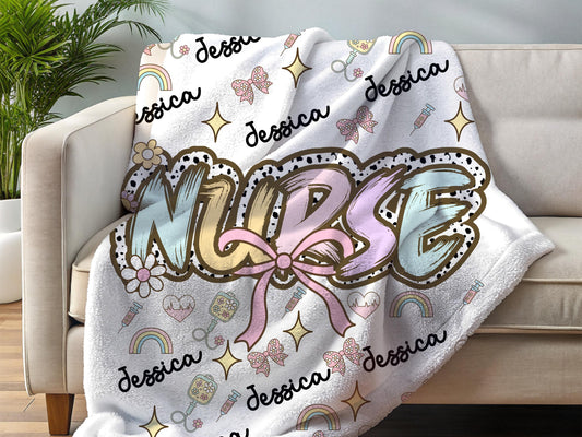 Personalized nurse name blanket  with the word nurse in a pastel dalmation dot  print and pink bow, with name and nurse accessories surrounding perfect gift for nurses